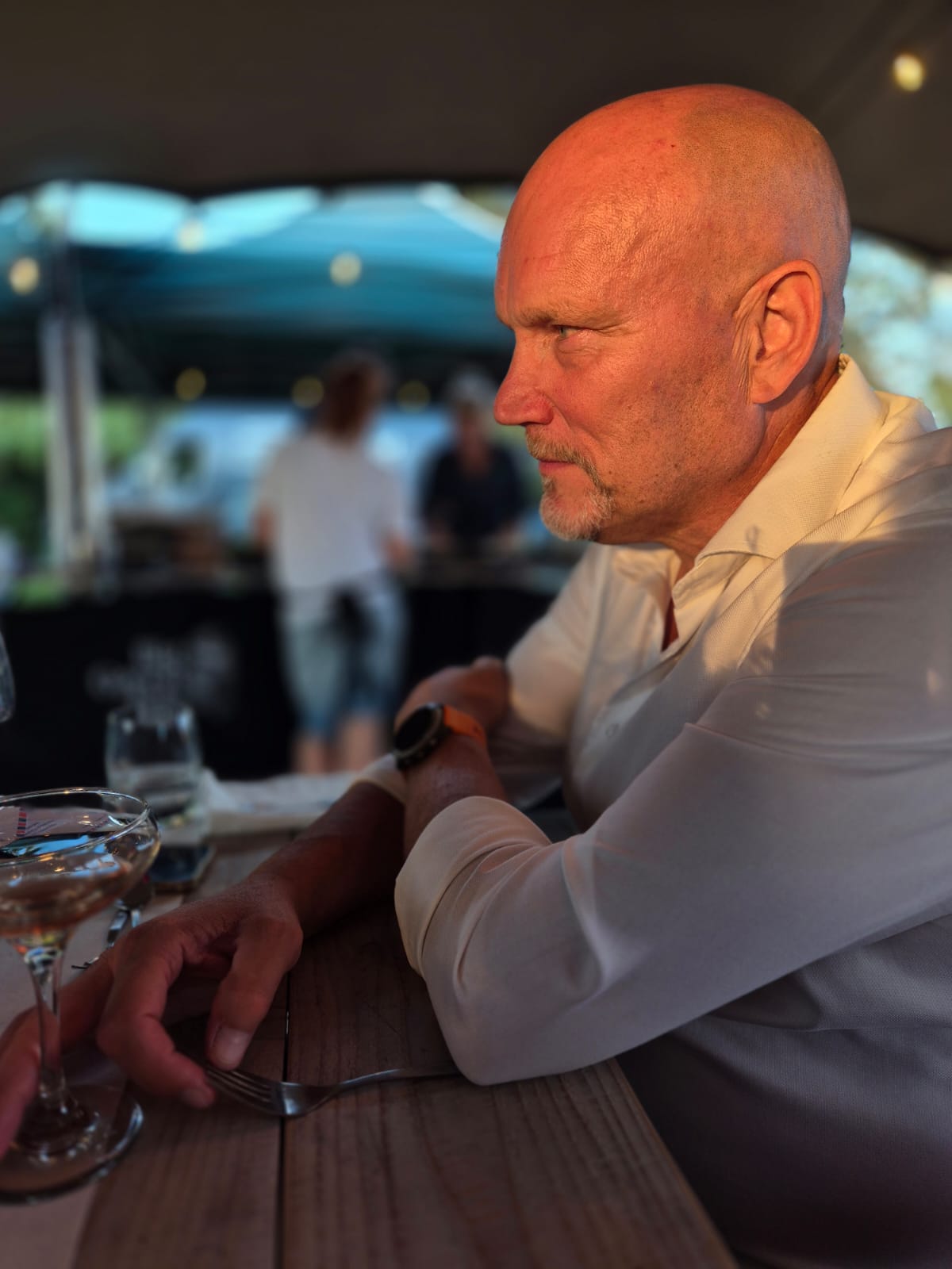 Hans Krijger with long blonde hair, wearing a light blue polo shirt, touching the back of a dark horse Hans Krijger with long blonde hair, wearing a light blue polo shirt, touching the back of a dark horse