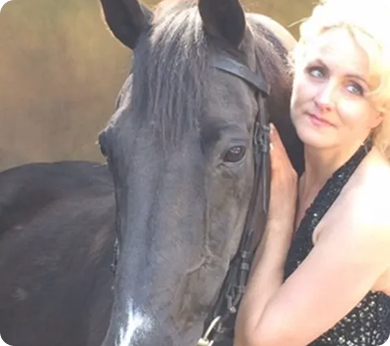 Iris Smalbeek with blonde hair, smiling softly, with the head of a dark horse positioned closely beside her Iris Smalbeek with blonde hair, smiling softly, with the head of a dark horse positioned closely beside her